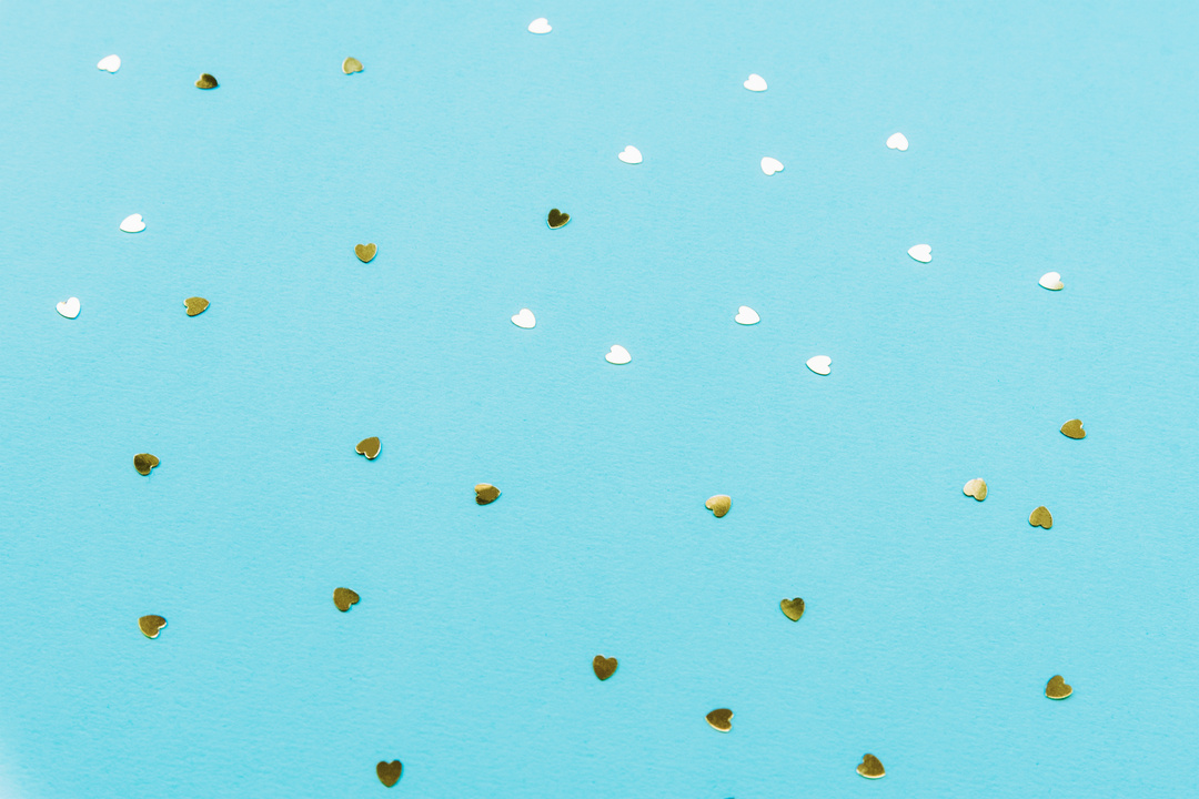 Golden hearts confetti on teal blue background. Valentines