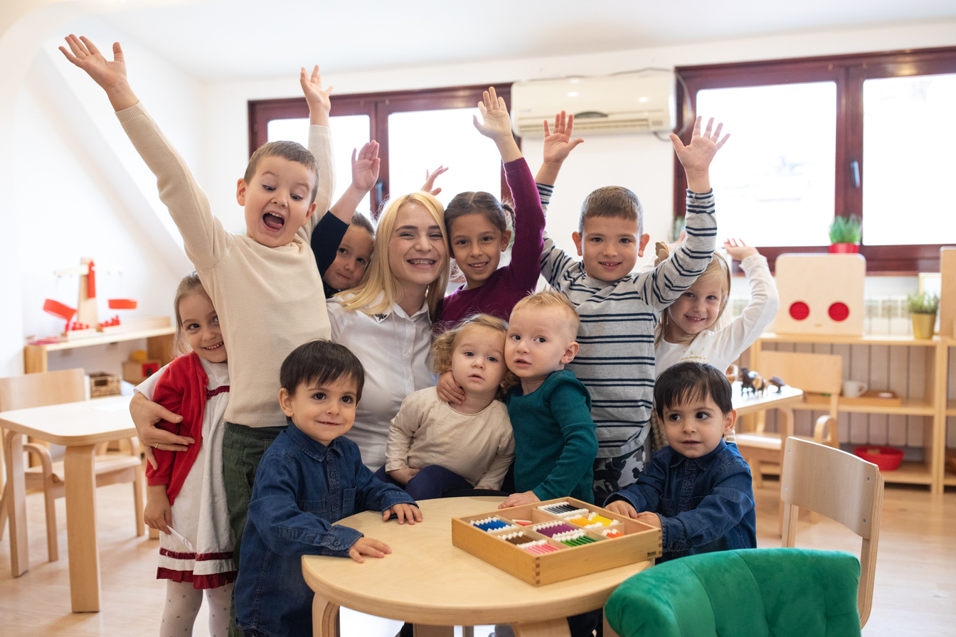 Cheerful kids and their teacher in child care classroom